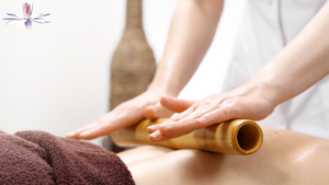 Massage therapist performing a warm bamboo fusion massage on a client to relieve tension and promote relaxation.